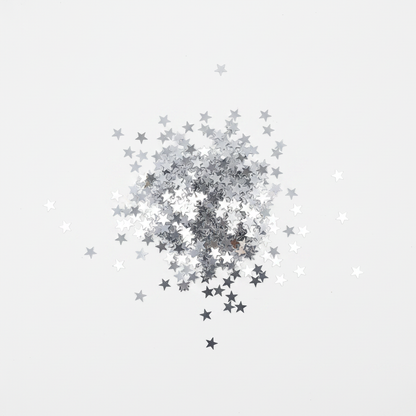 Silver metallic star confetti flat lay top down view on white surface sparkling stars