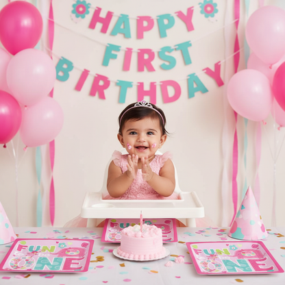 Baby girl at first birthday party with Fun to be One plates