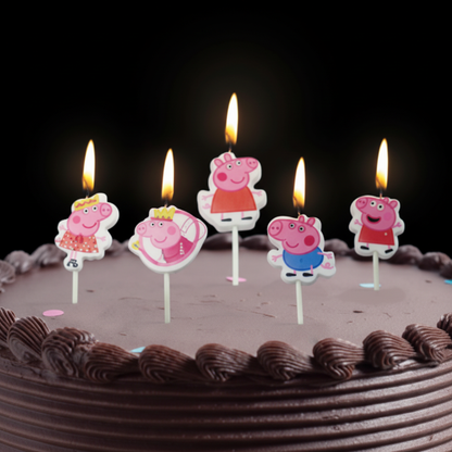 Peppa Pig candles lit on chocolate birthday cake dark moody style