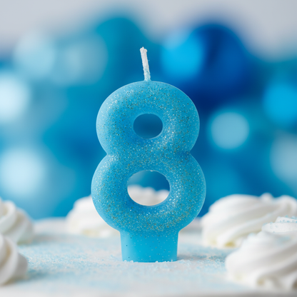 Close up detail of blue glitter number 8 birthday candle showing vivid blue glitter finish